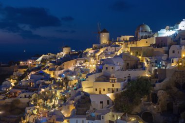 Santorini - yel değirmenleri ile Oia parçası bakmak alacakaranlıkta.