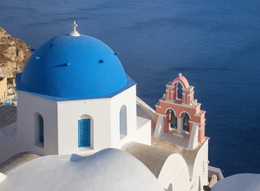 Santorini - Oia küçük çan kulesinde caldera üzerinde ile kilise cupolas genellikle mavi göz.