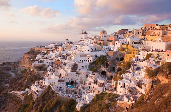 SANTORINI, GÖRÖGORSZÁG - 2015. október 4.: A kilátás Oia egy részére a szélmalmokkal az esti fényben. — Stock Fotó