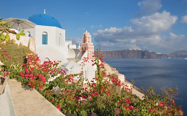 Santorini - utseendet över blommorna till vanligtvis kyrkan i Oia över calderan. — Stockfoto