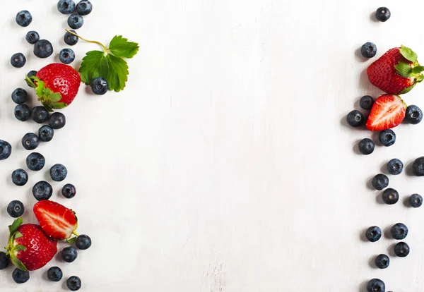 Fragole fresche e mirtilli su fondo di legno — Foto Stock