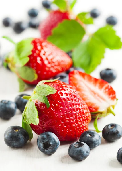 Fragole fresche e mirtilli su fondo di legno — Foto Stock