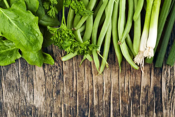 Verdure verdi fresche su sfondo di legno — Foto Stock