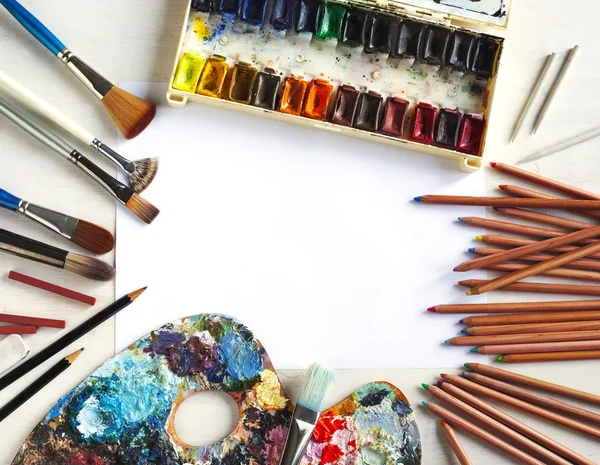 Käytetty vesi-väri maali-laatikko, sivellin, kynät ja pastellit — kuvapankkivalokuva