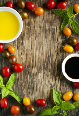 Taze domates, fesleğen, zeytinyağı ve ahşap arka plan üzerinde balsamik sirke