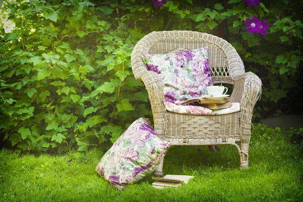 Kopje thee met een boeken op een stoel in de tuin. — Stockfoto