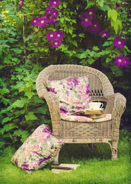 Kopje thee met een boeken op een stoel in de tuin. — Stockfoto
