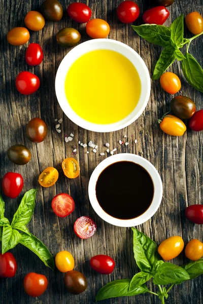 Fresh tomatoes, basil, olive oil and balsamic vinegar on wooden background — Stock Photo, Image