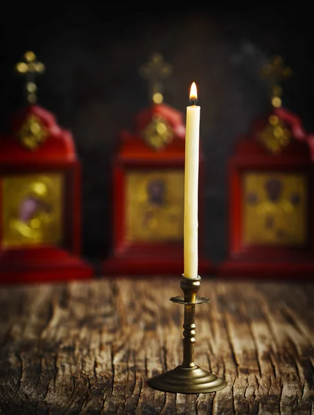 Burning candle against the background of the Christian icons — Stock Photo, Image