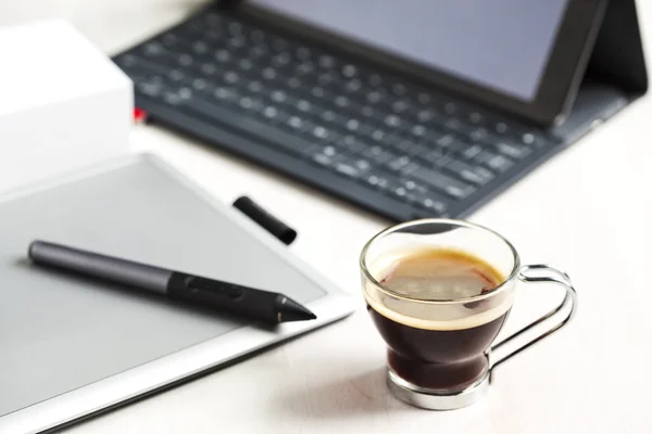 Digital tablet, stylus pen, tablet pad and cup of coffee.