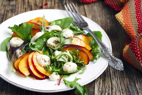 Peach and marinated mozzarella salad with fresh mixed greens — Stock Photo, Image