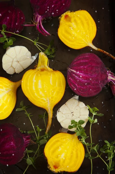 Preparing raw beetroots and garlic for roasting on a baking tray — Stock Photo, Image