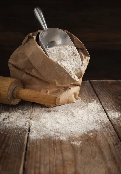 Rye flour in brown paper bag on wooden background. — Stock Photo, Image
