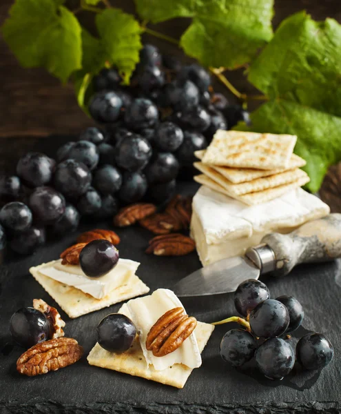 Läckra ostar kex förrätt med druvor och pekannötter — Stockfoto