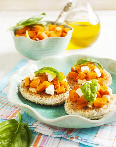 Kürbisbruschetta. Bruschetta mit geröstetem Kürbis, Käse und Basilikum — Stockfoto