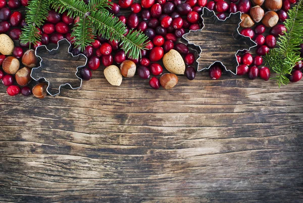 Christmas border with cranberries, spruce branch and cookie cutters — Stock Photo, Image