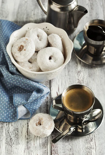 Donuts sucrés avec sucre glace et deux tasses de café — Photo