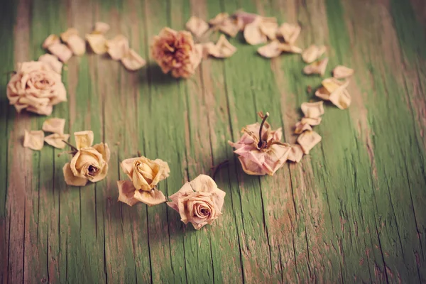 Corazón vintage de rosas secas sobre fondo de madera . — Foto de Stock