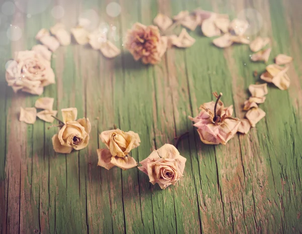 Corazón vintage de rosas secas sobre fondo de madera . — Foto de Stock