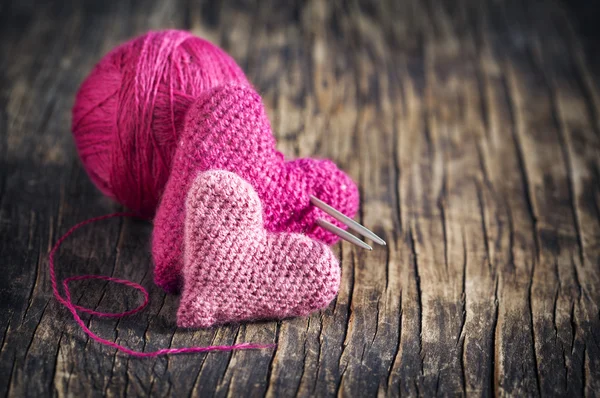 Two crochet pink hearts on wooden background — Stock Photo, Image