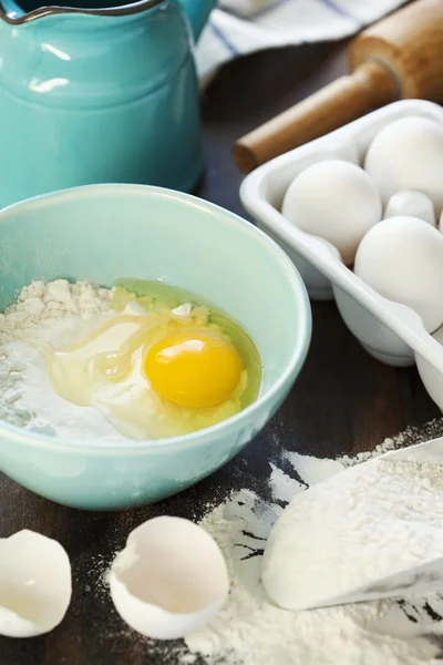 Harina y huevos en una mesa de madera — Foto de Stock