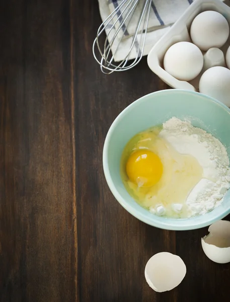 Мука и яйца на деревянном столе — стоковое фото
