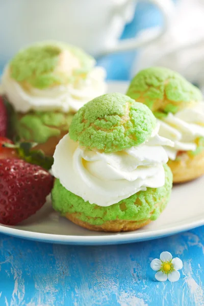 Profiteroles with strawberry compote and whipped cream. — Stock Photo, Image