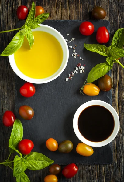Čerstvá rajčata, bazalka, olivový olej a balsamico ocet na dřevěné pozadí — Stock fotografie