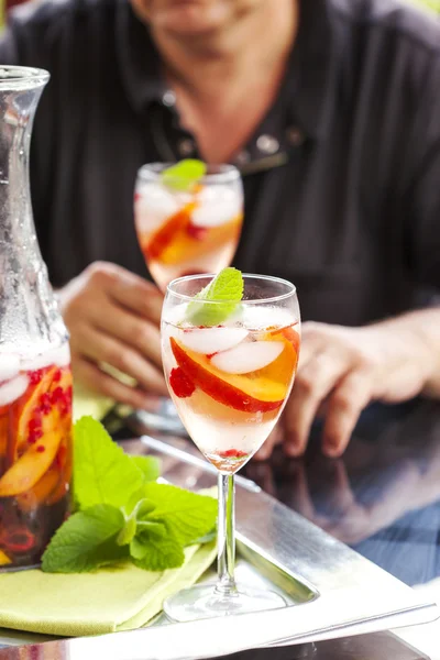 Man drinking white sangria. White sangria with fruits and berries — Stock Photo, Image