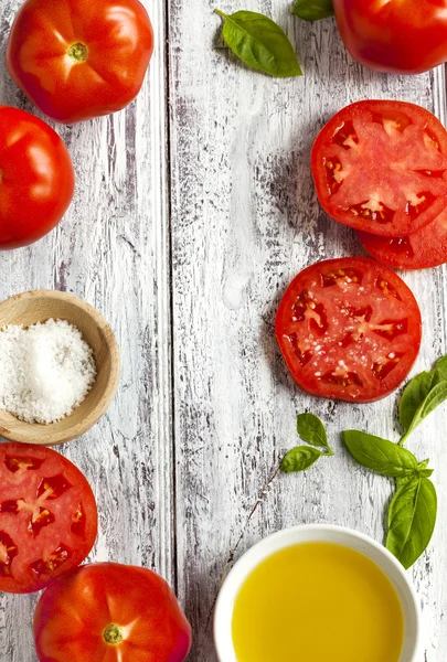 Tomates fraîches, basilic, huile d'olive et sel sur fond de bois — Photo