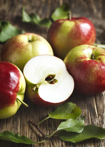 Pommes biologiques fraîches avec des feuilles sur fond en bois — Photo