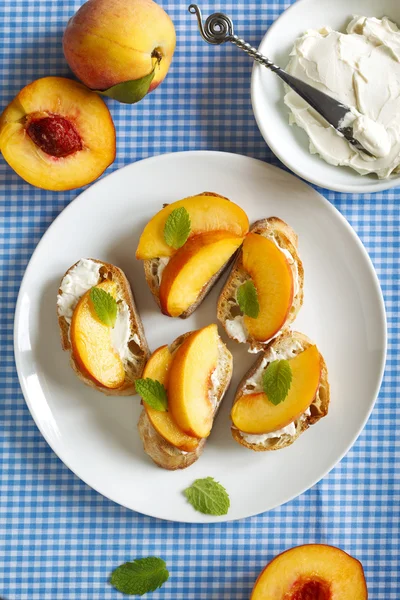 Crostini com creme de queijo e pêssegos frescos . — Fotografia de Stock