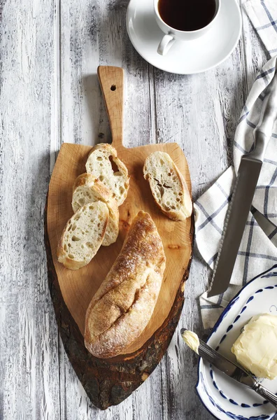 Bröd med smör och kopp te på träbord. Ovanifrån — Stockfoto