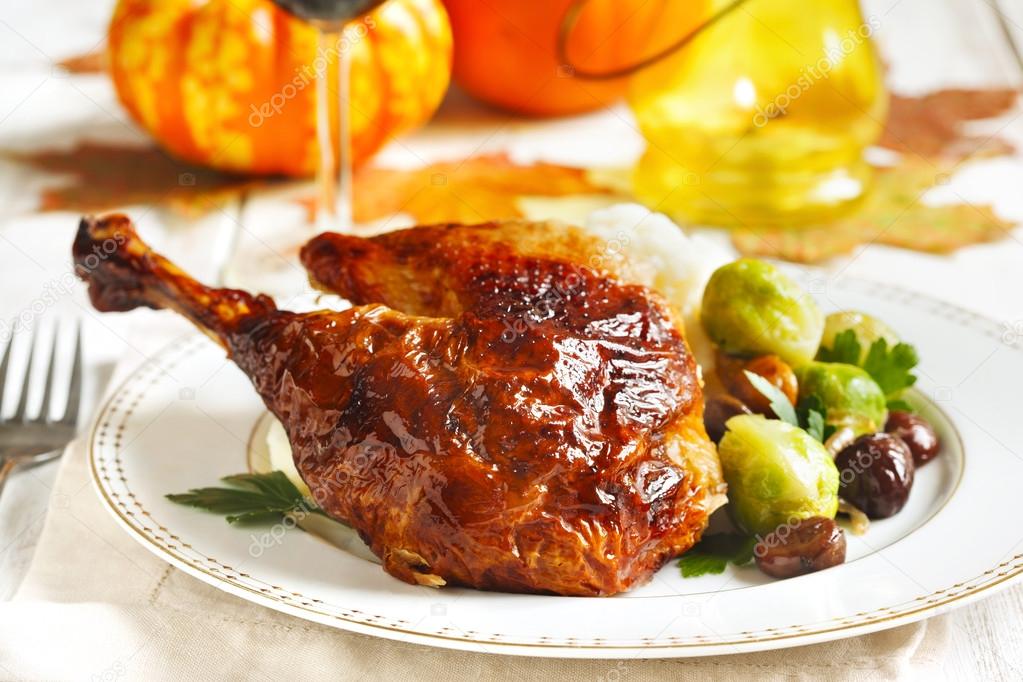 Roasted turkey leg garnished with mash potato, chestnuts and brussels sprouts