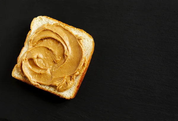 Sandwich de mantequilla de maní sobre fondo negro con espacio para copiar — Foto de Stock