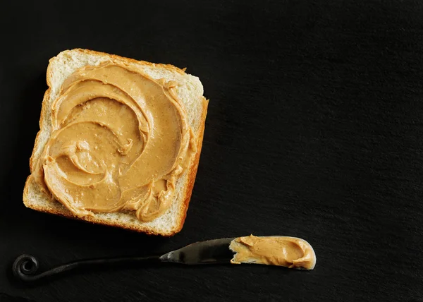 Sandwich de mantequilla de maní sobre fondo negro con espacio para copiar — Foto de Stock