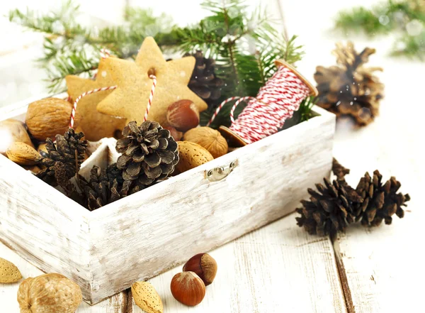 Christmas cookies, walnuts, nuts and pine cones in wooden box. — Stock Photo, Image