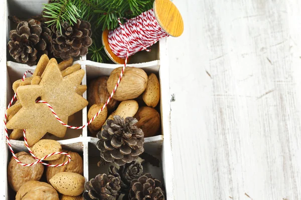 Noel kurabiyeleri, ceviz, fındık ve çam kozalakları ahşap kutusunda. — Stok fotoğraf