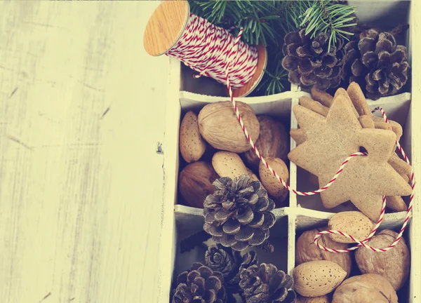 Christmas cookies, walnoten, noten en dennenappels in houten kist. — Stockfoto