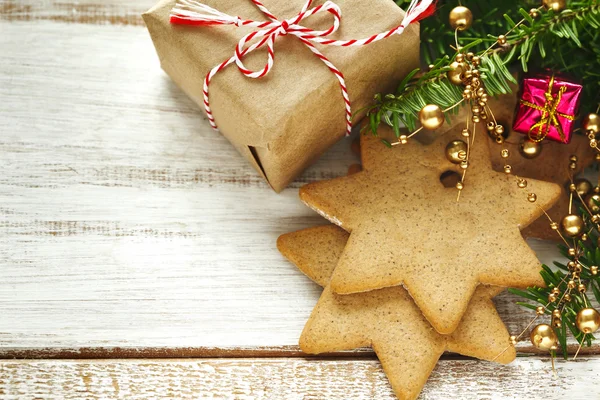 Biscoitos de Natal e presente no fundo de madeira — Fotografia de Stock