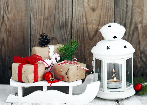 Vánoční dárky na saních a svíčka — Stock fotografie