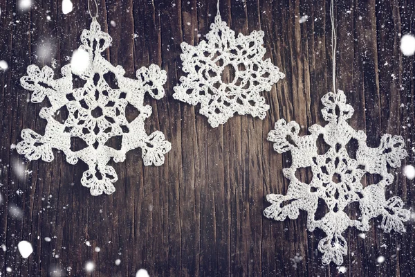 Crocheted white snow flakes on wooden background — Stock Photo, Image