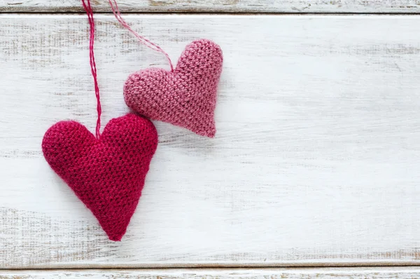 Crochet pink hearts on wooden background — Stock Photo, Image