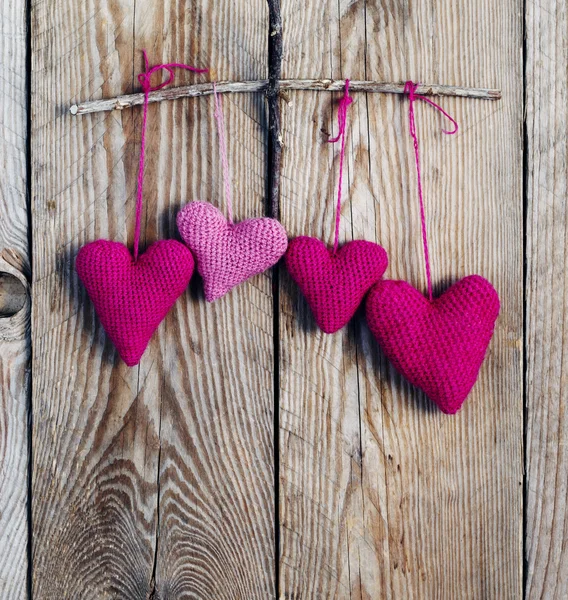 Horgolt rózsaszín szívekkel fából készült háttér. — Stock Fotó