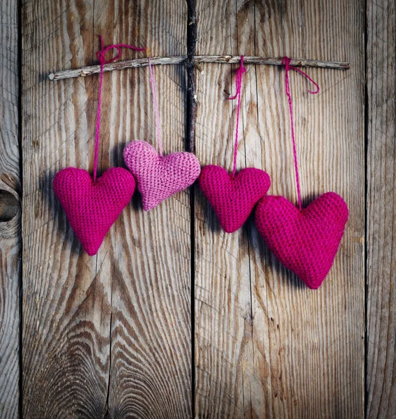 Crochet pink hearts on wooden background. — Stock Photo, Image