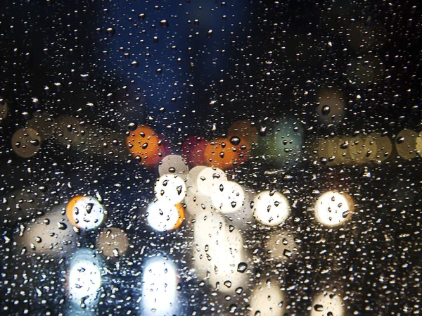 フロント ガラスを通して夜の街。フォーカスの通りボケ ライトはアウト. — ストック写真