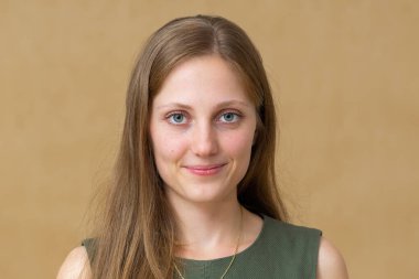 Genç sarışın model stüdyoda kameraya gülümsüyor.