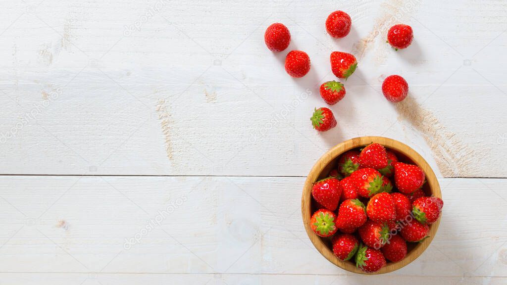 Red strawberries laying on white table from above with copy space.