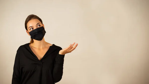 Woman with face mask holding hand by her side and looking into empty copy space — Stock Photo, Image