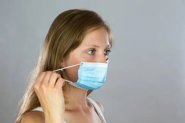 Close-up of a woman removing face mask from head with her fingers — Stock Photo, Image